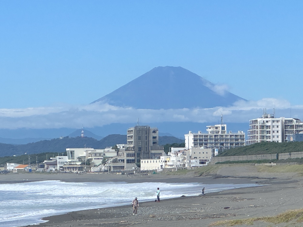 10月6日10時すぎの湘南茅ヶ崎の浜。富士山を背にした砂浜を3人が歩いている